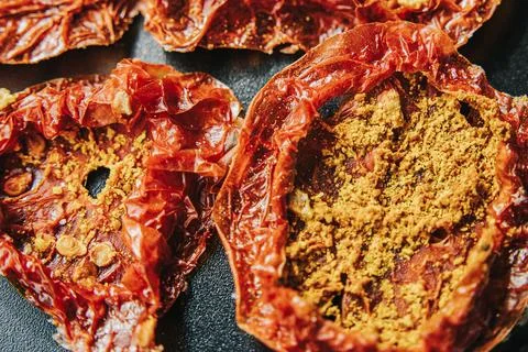 Overhead close-up of multiple sun-dried tomato slices coated. Stock Photos