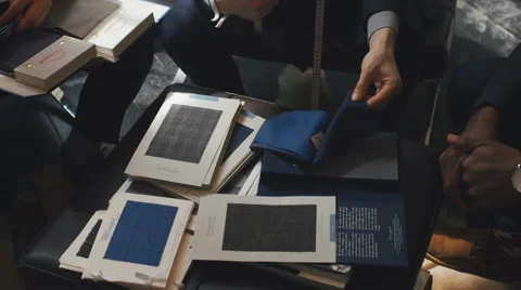 Overhead Close Up of Three Young Men Looking at Fine Fabrics for Suits Video stock 62554801