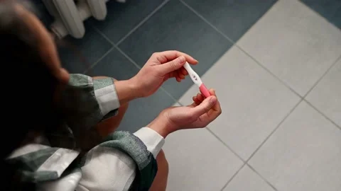 Overhead close-up view of woman's hands, holding jet pregnancy test, showing Video stock 230017513