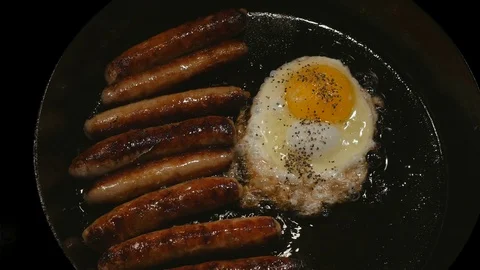 Overhead Closeup link sausage peppered egg cast iron skillet black background Stock Footage 72585595