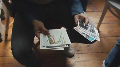 Overhead Closeup Shot of Man Looking at Art Prints Stock Footage 64965123
