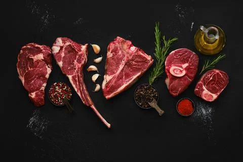 Overhead composition with raw prime beef cuts - porter house, cowboy steak, o Foto stock
