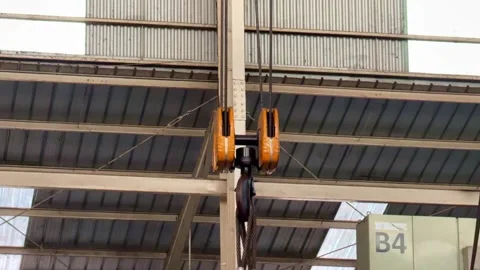 Overhead crane hook and pulley system in industrial warehouse. Stock Footage 341378857