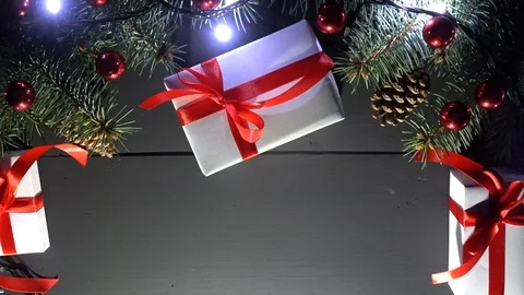 Overhead decoration on black background with cones, gifts, baubles and lights 스톡 동영상 99010163