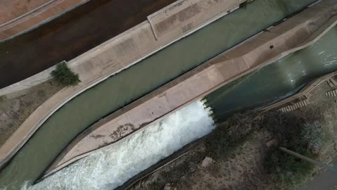 Overhead descent to high flow water runoff from hydroelectric reservoir Stock Footage 333633436