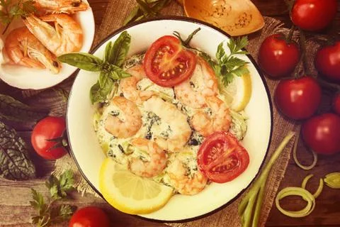 Overhead of dinner table. Seefood casserole with leek, cheese, grilled shrimp Stock Photos