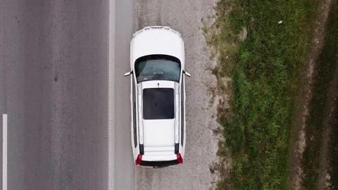 Overhead directly above view of a man sitting in car parked at road side of h Stock Footage 142750924