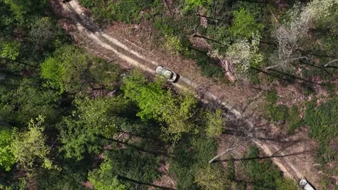 Overhead drone capturing off-road vehicles passing under Stock Footage 344999518