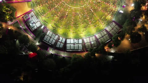 An overhead drone moves from dark trees across the perimeter seating to reveal 스톡 동영상 347786178