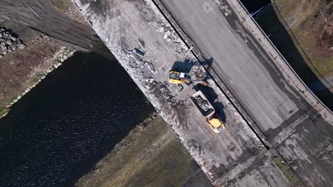 Overhead drone perspective showing heavy plant machinery active on a bridge Stock Footage 333152181