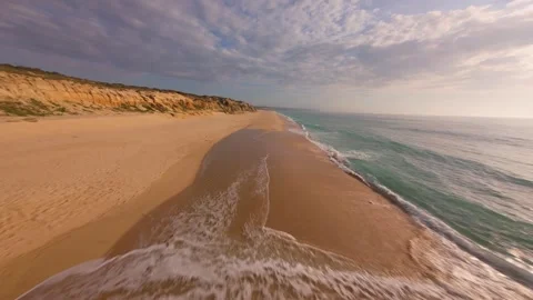 Overhead drone shot captures calm beach meeting ocean at sunset Stock Footage 340225780