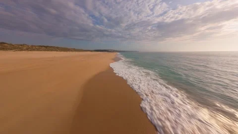 Overhead drone shot captures calm beach meeting ocean at sunset Stock Footage 340225838
