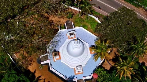 An overhead drone shot captures a white octagonal stupa or pagoda surrounded by Vídeo Stock 330867307