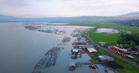 Overhead drone shot of fish cage on the lakeside with fishing village Stock Footage 228325207