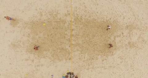 Overhead drone shot of four men playing footvolley on the beach Stock Footage 114854892
