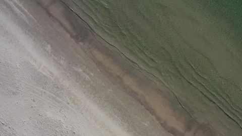Overhead Drone shot looking down at waves breaking on perfect clean beach Vidéo 280494766