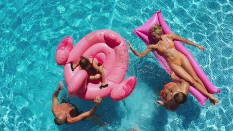 Overhead Drone Shot Of Multi-Generation Family With Inflatables On Summer Stock Footage 210859011