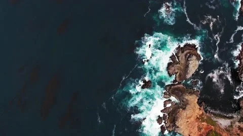 Overhead drone shot of ocean beating the rocky cape at Big Sur, California, USA Video stock 143047514