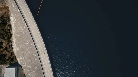 Overhead drone shot over a road on a dam in front of a river (Montana, USA) Stock Footage 123392804