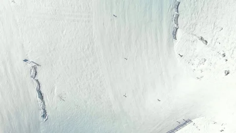 Overhead drone shot of skiers going down a snowy alpine run. Stock Footage 101770415