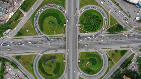 Overhead drone shot of traffic driving over roundabout with highway tunnel Stock Footage 135400007