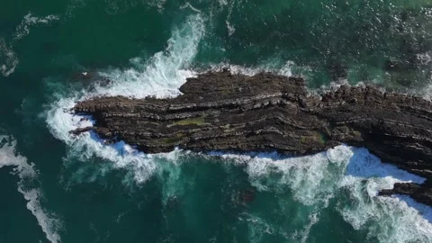 Overhead drone shot of waves washing over a stratified rock reef, Portugal Stock Footage 346377569