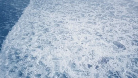 Overhead drone shot of white wave dissolving in the blue ocean Ariya's Beach Video stock 123392281