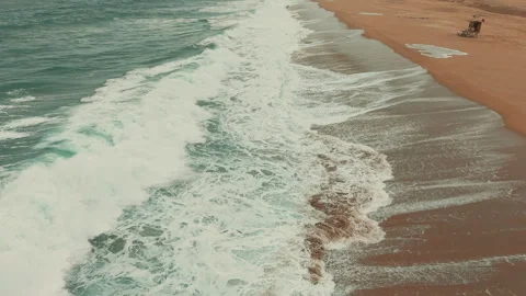 Overhead drone view of foamy Pacific Ocean waves breaking along Newport Beach Stock Footage 347744124