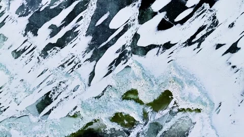 Overhead drone view of frozen Baltic Sea ice with elongated snow patches Stock Footage 333652169