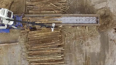 Overhead drone view of machine adding logs into an industrial wood chipper Stock Footage 165799547