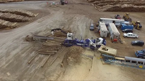 Overhead drone view of machine adding logs into an industrial pulp mill Stock Footage 165799560