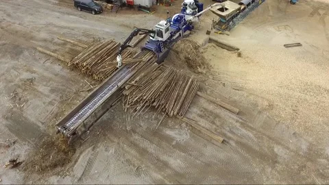 Overhead drone view of machine and operator adding logs into an industrial Stock Footage 165799623