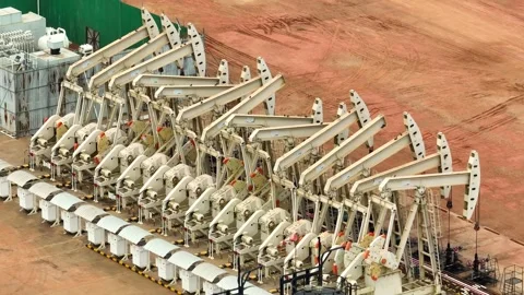 Overhead drone view of oil pumpjacks in a structured row. Stock Footage 331280243