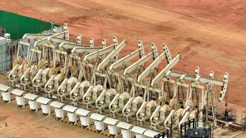 Overhead drone view of oil pumpjacks in a structured row. Stock Footage 331280256