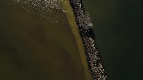 Overhead drone view of an old mole in the sea made from wood and stones Stock Footage 105295587