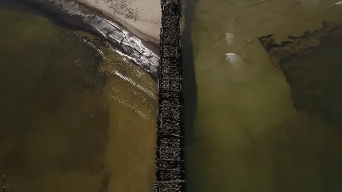 Overhead drone view of an old mole in the Baltic sea made from wood and stones Stock Footage 105295926