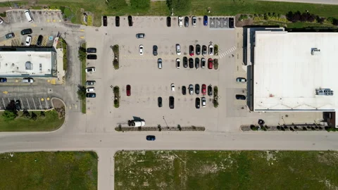 Overhead drone view of a retail store parking lot with parked cars, access 스톡 동영상 347576185