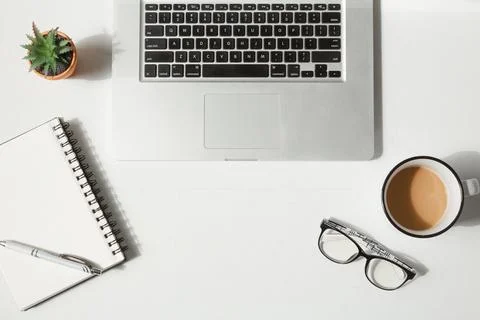 Overhead Flat Lay of Laptop, Blank Notepad, Coffee, Glasses, and Succulent .. Foto stock