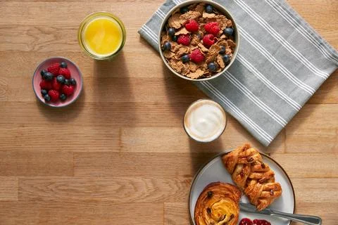 Overhead Flat Lay Shot Of Table Laid For Breakfast With Cereal Pastries And Stock Photos