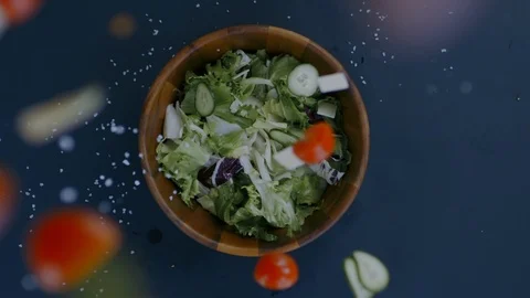 OVERHEAD FLAT LAY Sliced tomatoes, cucumbers, salt and cheese falling into salad Stock Footage 125898520