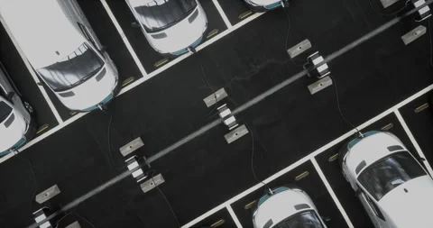 OVERHEAD Fleet of generic electric delivery vans charging on charging stations Stock Footage 245188491