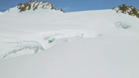 Overhead flight close above snow collapse, cave hollow on white mountain slope Stock Footage 126363711