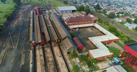 Overhead flight over rusty train yard with semi urban settlements Stock Footage 85953317