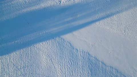 Overhead flight over textured snow with long shadows Stock Footage 232510328