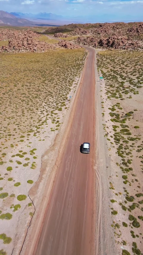 Overhead follow shot tracking car driving on straight dirt road across 库存影片 340990868