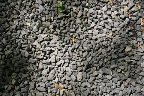 Overhead full frame view of rough grey gravel rocks illuminated by natural Фото