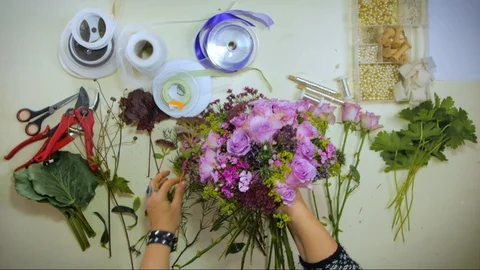 Overhead Hands of a florist puts together a bouquet of flowers Stock Footage 88824746