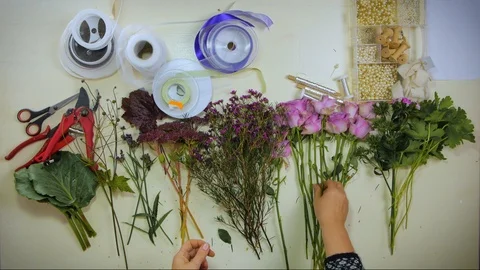 Overhead Hands of a florist puts together a bouquet of flowers Stock Footage 88970146