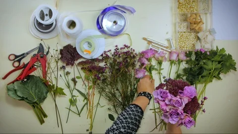 Overhead Hands of a florist puts together a bouquet of flowers Stock Footage 88971085