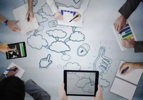 Overhead of hands writing with blue surface and and blue cloud doodles Stock Photos